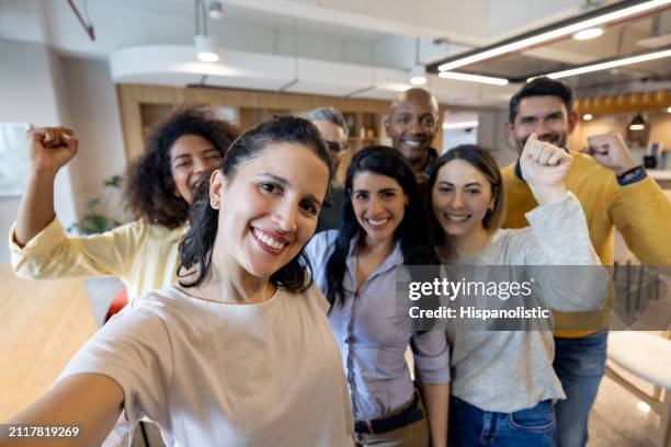 successful group of business people at the office celebrating an achievement - hispanolistic stock pictures, royalty-free photos & images