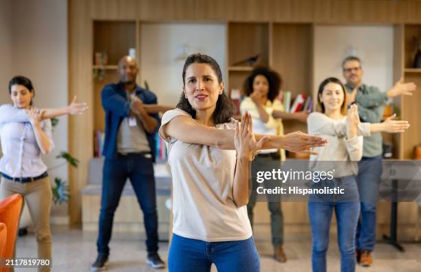 business people taking a break and stretching at the office - hispanolistic stock pictures, royalty-free photos & images