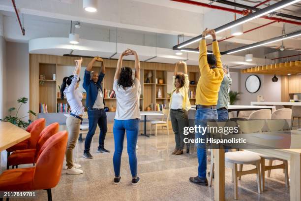 gente de negocios que toma un descanso activo en la oficina y se estira - estirándose fotografías e imágenes de stock