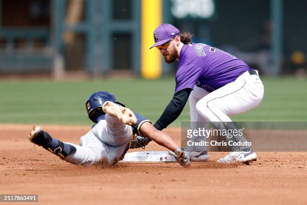 Brendan Rodgers of the Colorado Rockies tags out Eric Brown Jr of the Milwaukee Brewers during the second inning of a spring training game at Salt...