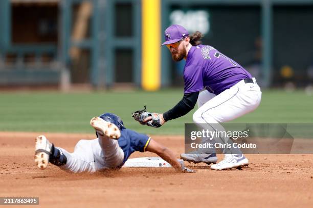 Brendan Rodgers of the Colorado Rockies tags out Eric Brown Jr of the Milwaukee Brewers during the second inning of a spring training game at Salt...