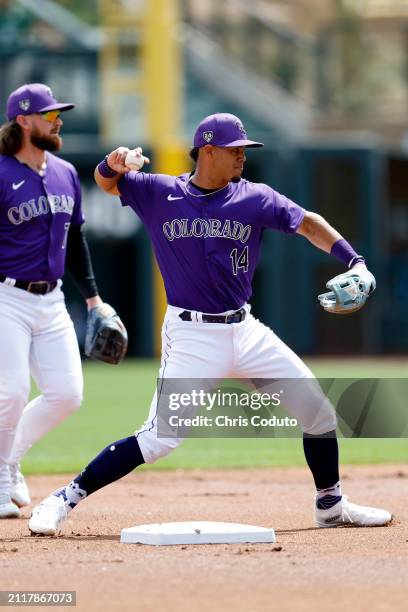 Ezequiel Tovar of the Colorado Rockies throws to first base during a spring training game against the Milwaukee Brewers at Salt River Fields at...