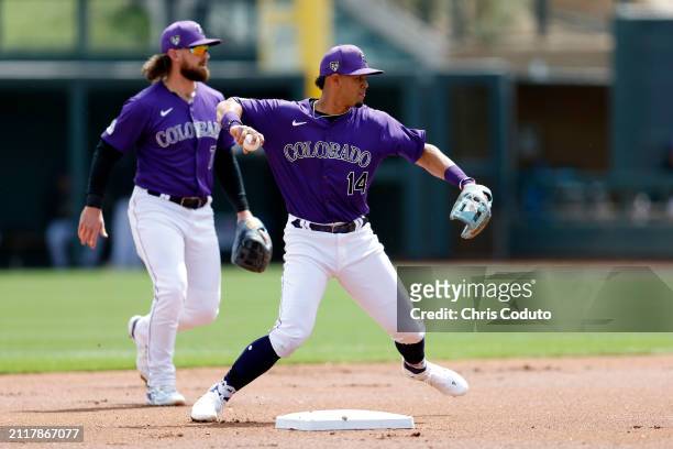 Ezequiel Tovar of the Colorado Rockies throws to first base during a spring training game against the Milwaukee Brewers at Salt River Fields at...