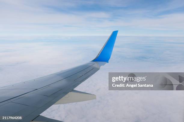 airplane wing over clouds viewed from cabin window - aircraft wing stock pictures, royalty-free photos & images