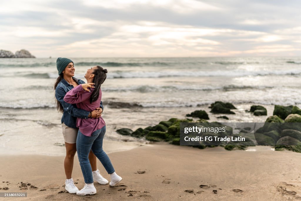 Lesbian couple dancing on the beach