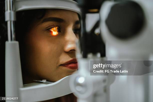 close-up of young woman doing optical exam at medical clinic - astigmatismo imagens e fotografias de stock