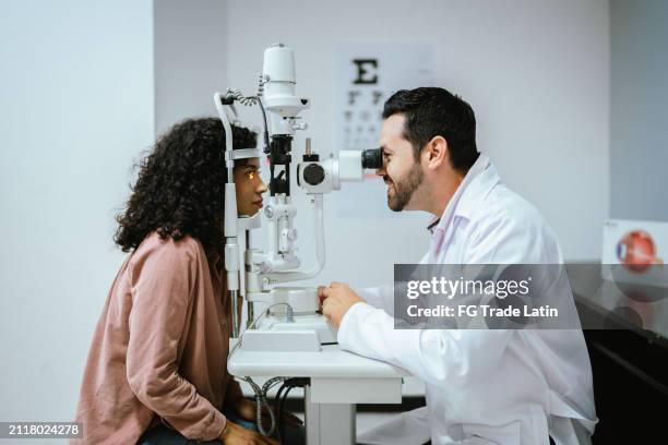 junge frau macht optische untersuchung in der medizinischen klinik - augenkrankheit stock-fotos und bilder