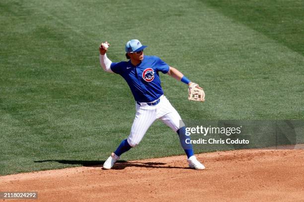 Nico Hoerner of the Chicago Cubs throws to first base during a spring training game against the St. Louis Cardinals at Sloan Park on March 25, 2024...