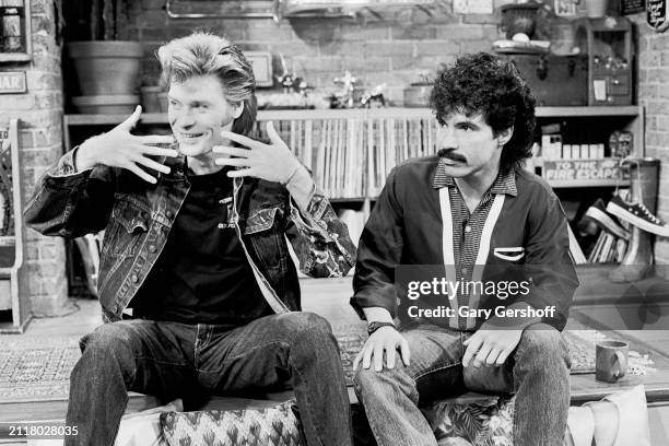 View of American Pop musicians Daryl Hall and John Oates, both of the duo Hall & Oates, as they sit on a low stage during an interview on MTV at...