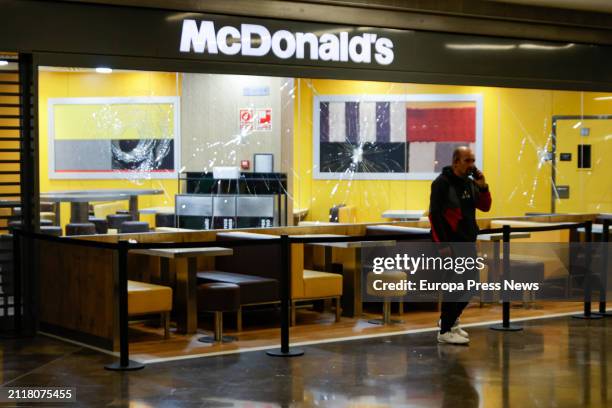 Person passes in front of the McDonald's window with broken glass at the Magic Badalona shopping center, on 27 March, 2024 in Badalona, Catalonia,...