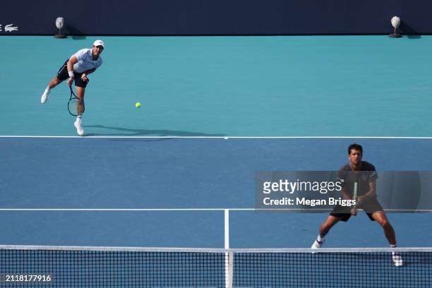 Edouard Roger-Vasselin of France and Marcelo Melo of Brazil serve to Ivan Dodig of Croatia and Austin Krajicek of the United States during their...