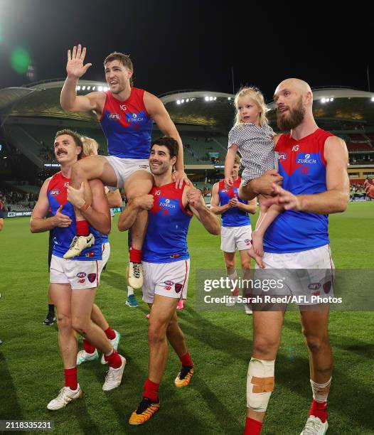 Jack Viney of the Demons gets chaired off in his 200th game by Jake Lever and Christian Petracca wth Max Gawn walking along side during the 2024 AFL...