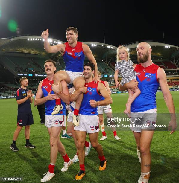 Jack Viney of the Demons gets chaired off in his 200th game by Jake Lever and Christian Petracca wth Max Gawn walking along side during the 2024 AFL...