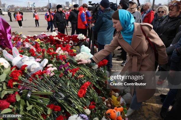 Woman places flowers at a memorial for the victims of the Crocus City Hall attack near Crocus City Hall, March 30, 2024 in Krasnogorsk, Russia. On...