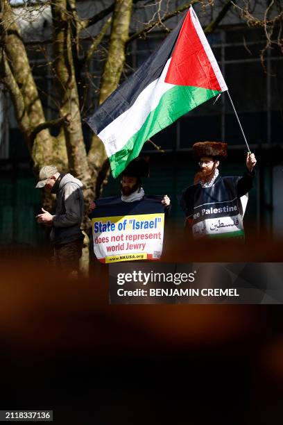 Members of the Ultra-Orthodox Jewish community wave a Palestinian flag and hold placards as they join pro-Palestinian activists and supporters for a...