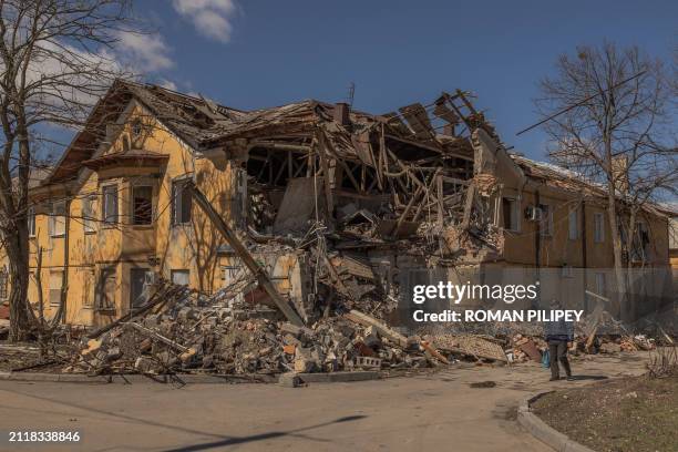 Pedestrian walks past a building that was heavily damaged following a recent shelling, in the town of Mykolaivka, near Sloviansk in the north of the...