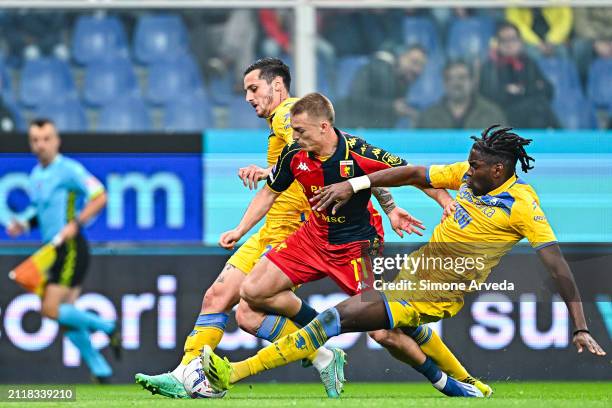 Albert Gudmundsson of Genoa gets tackled by Emanuele Valeri and Caleb Okoli of Frosinone and earns a penalty kick during the Serie A TIM match...