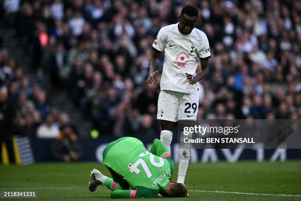 Luton Town's Belgian goalkeeper Thomas Kaminski stops the ball in front of Tottenham Hotspur's Senegalese midfielder Pape Matar Sarr during the...