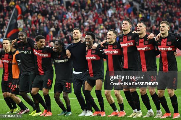 Bayer Leverkusen's Spanish head coach Xabi Alonso and his players celebrate winning the German first division Bundesliga football match Bayer 04...