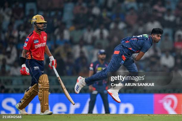 Lucknow Super Giants' Mayank Yadav bowls as Punjab Kings' captain Shikhar Dhawan watches during the Indian Premier League Twenty20 cricket match...