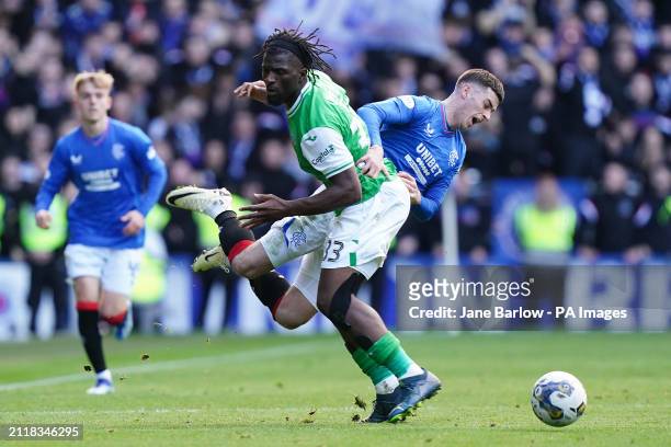 Hibernian's Rocky Bushiri and Rangers' Tom Lawrence battle for the ball during the cinch Premiership match at Ibrox Stadium, Glasgow. Picture date:...