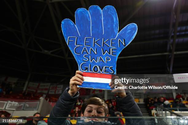 Young fan holds up a giant cardboard glove asking to swap gloves with Brentford goalkeeper Mark Flekken during the Premier League match between...