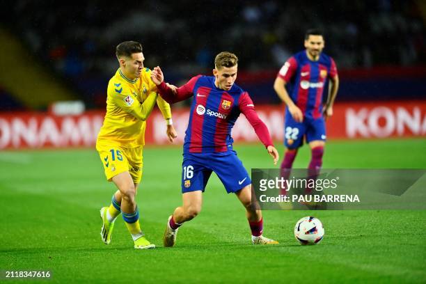 Las Palmas' Spanish defender Mika Marmol fights for the ball with Barcelona's Spanish midfielder Fermin Lopez during the Spanish league football...
