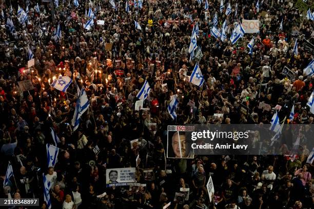 Protesters hold signs as they are taking part in a demonstration calling for the release of hostages held in the Gaza Strip, and against Israeli...