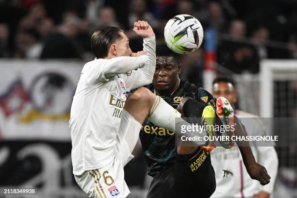Reims' Zimbabwean midfielder Marshall Nyasha Munetsi fights for the ball with Lyon's French midfielder Maxence Caqueret during the French L1 football...