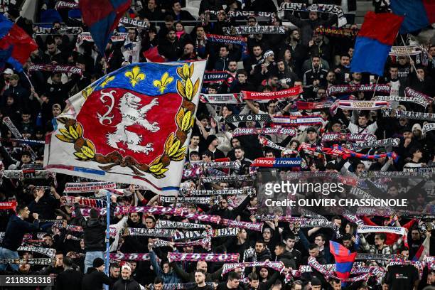 Lyon supporters hold scarves and wave flags during the French L1 football match between Olympique Lyonnais and Stade de Reims at The Groupama Stadium...