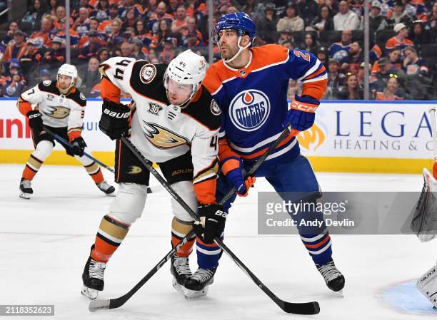 Evan Bouchard of the Edmonton Oilers battles for position against Ross Johnston of the Anaheim Ducks during the game at Rogers Place on March 30 in...