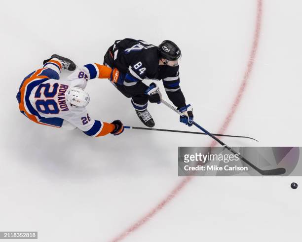 Tanner Jeannot of the Tampa Bay Lightning against Alexander Romanov of the New York Islanders during the first period at Amalie Arena on March 30,...