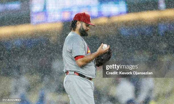 Pitcher Lance Lynn of the St. Louis Cardinals looks at the baseball before throwing a pitch against James Outman of the Los Angeles Dodgers in...