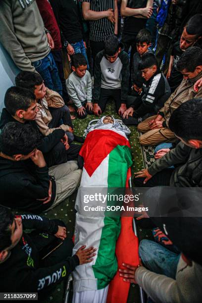 Mourners gather around the body of Mutasim Abu Abed and bid farewell during his funeral in Qabatiya, near the West Bank city of Jenin. Dr. Fawaz...