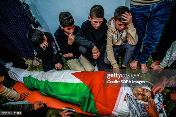 Mourners gather around the body of Mutasim Abu Abed and bid farewell during his funeral in Qabatiya, near the West Bank city of Jenin. Dr. Fawaz...