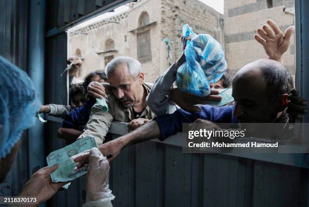People impacted by the war receive food from a local charity center on March 26, 2024 in Sana'a, Yemen. After nine years of conflict in the country,...