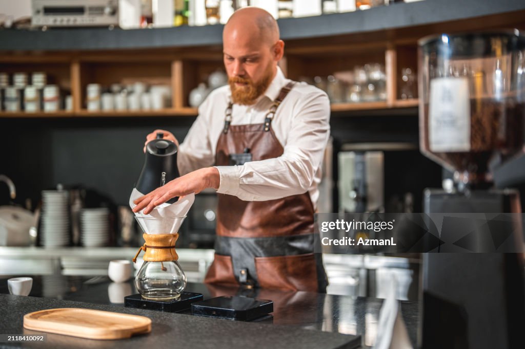 Caucasian Male's Professional Pour Over in a Cafeteria