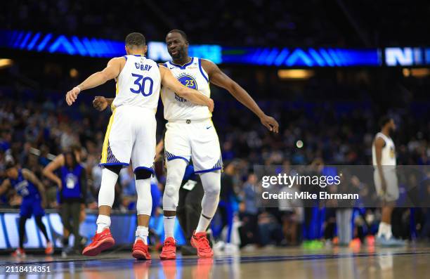 Stephen Curry and Draymond Green of the Golden State Warriors shake hands during a game against the Orlando Magic at Kia Center on March 27, 2024 in...