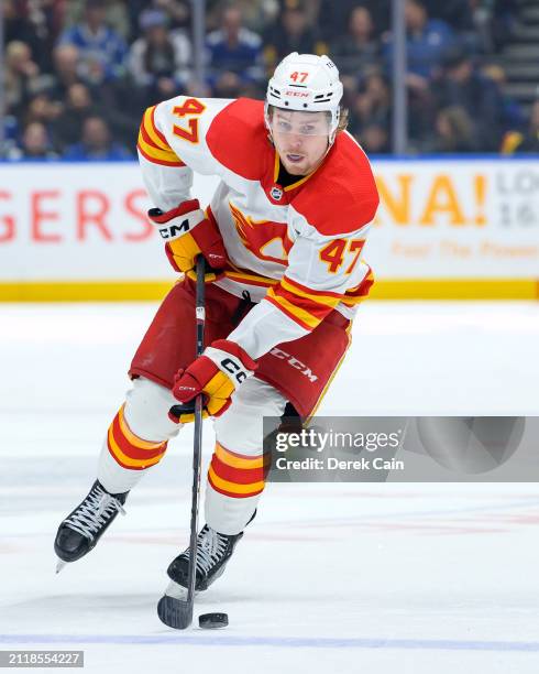 Connor Zary of the Calgary Flames skates with the puck during the second period of their NHL game against the Vancouver Canucks at Rogers Arena on...