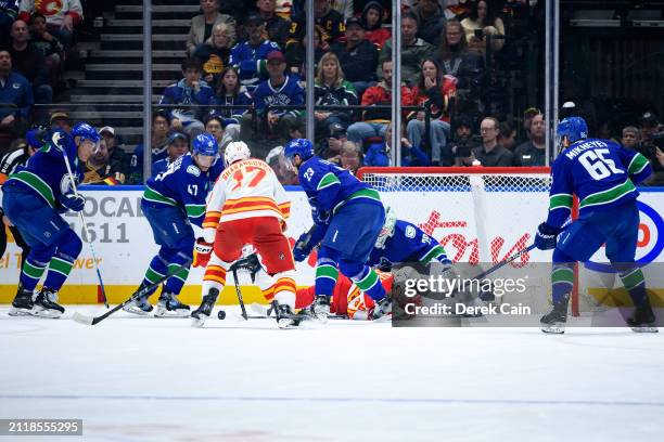 Casey DeSmith Noah Juulsen Nikita Zadorov and Elias Lindholm of the Vancouver Canucks defend against Andrei Kuzmenko of the Calgary Flames during the...