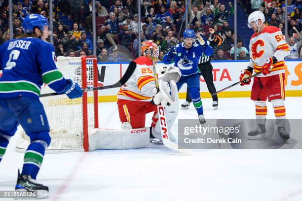 Elias Pettersson of the Vancouver Canucks celebrates a goal by J.T. Miller on Jacob Markstrom of the Calgary Flames during the third period of their...