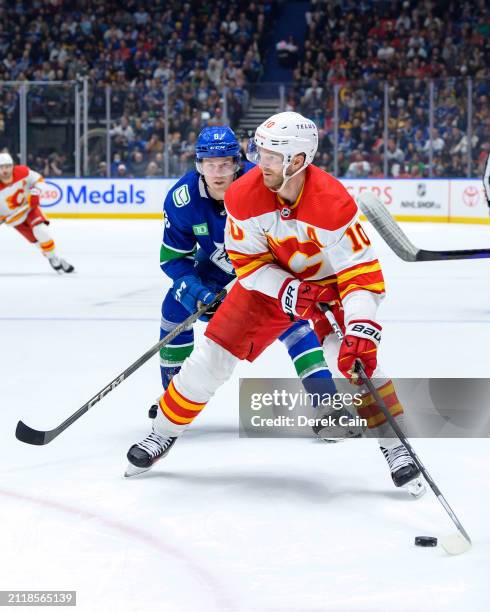 Jonathan Huberdeau of the Calgary Flames is pursued by Brock Boeser of the Vancouver Canucks during the second period of their NHL game at Rogers...