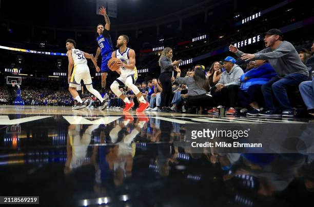 Stephen Curry of the Golden State Warriors drives on Cole Anthony of the Orlando Magic during a game at Kia Center on March 27, 2024 in Orlando,...