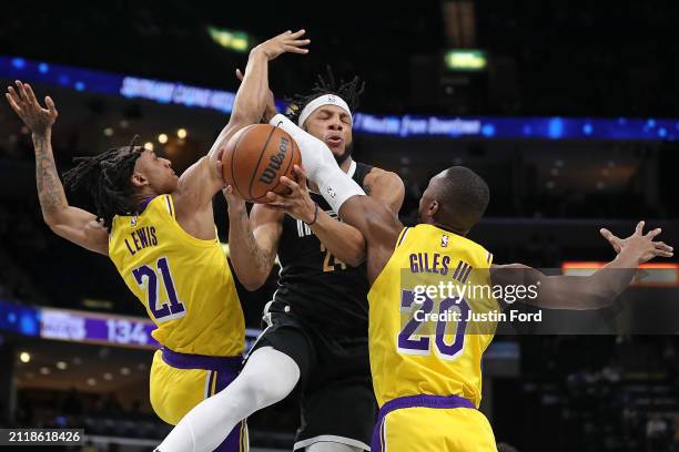 Lamar Stevens of the Memphis Grizzlies passes the ball between Maxwell Lewis of the Los Angeles Lakers and Harry Giles III during the second half at...