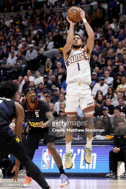 Devin Booker of the Phoenix Suns puts up a shot against Kentavious Caldwell-Pope of the Denver Nuggets during the first quarter at Ball Arena on...