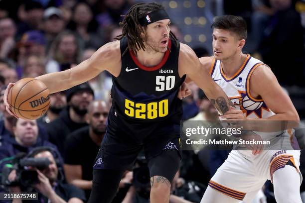 Aaron Gordon of the Denver Nuggets drives against Grayson Allen of the Phoenix Suns during the first quarter at Ball Arena on March 27, 2024 in...