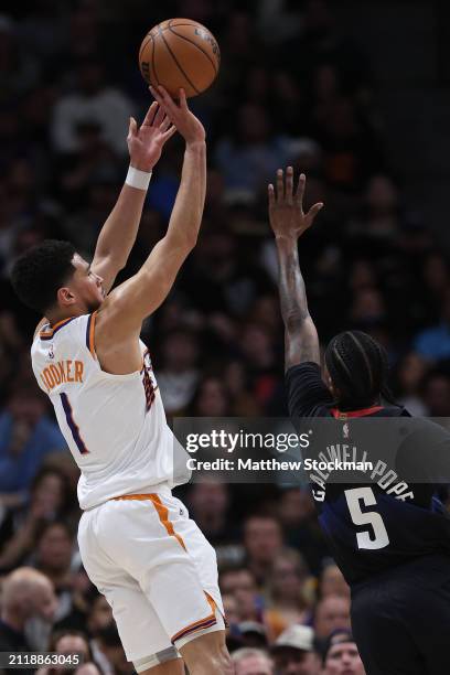 Devin Booker of the Phoenix Suns puts up a shot against Kentavious Caldwell-Pope of the Denver Nuggets during the thired quarter at Ball Arena on...