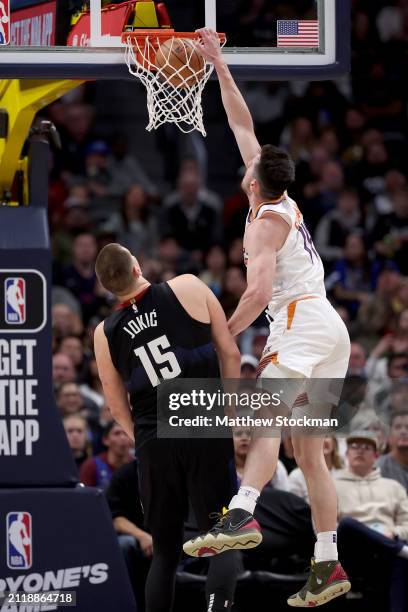 Drew Eubanks of the Phoenix Suns dunks on Nikola Jokic of the Denver Nuggets during the third quarter at Ball Arena on March 27, 2024 in Denver,...