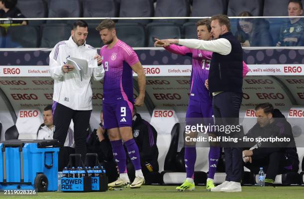 Head coach Julian Nagelsmann of Germany talks to Thomas Müller of Germany before his substitution, Assistant coach Mads Buttgereit talks to Niclas...