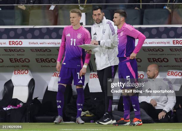 Assistant coach Mads Buttgereit of Germany talks to Chris Führich and teammate Pascal Gross before their substitution during the international...